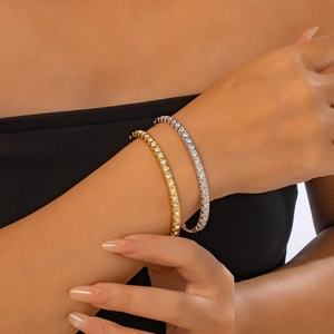 Primer plano de pulseras de acero de titanio en oro y plata con circonitas para mujer
