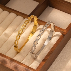 Detalle de brazaletes de acero inoxidable con diamantes oro y plata en joyero de lujo