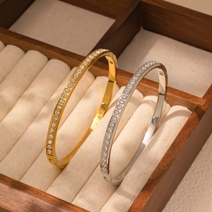 Detalle de brazaletes de trébol dorados y plateados con circonitas en estuche de terciopelo