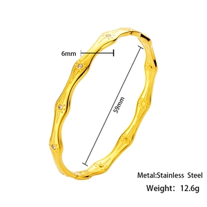 Macro detail of 6mm wavy gold stainless steel bracelet with sunburst and zircon inlay
