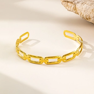 Dettaglio del bracciale a catena dorato con maglie rettangolari e superficie lavorata