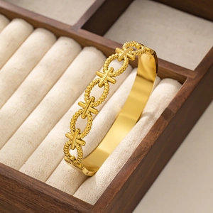 Macro detail of 18K gold plated stainless steel bracelet with bead and X-shaped links