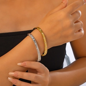 Detalle de brazaletes de hojas en oro y plata con circonitas usados en la muñeca
