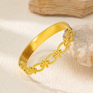 Detailed macro view of 18K gold plated bamboo-style hinge bangle on stone background