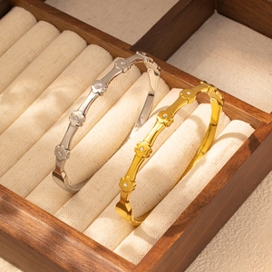 Detalle de brazaletes de rombos en oro y plata con diamantes incrustados y nudos florales