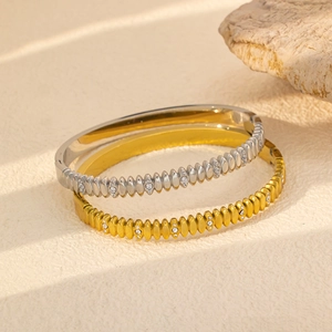 Detalle macro de brazaletes de rombos en oro y plata con circonitas sobre piedra