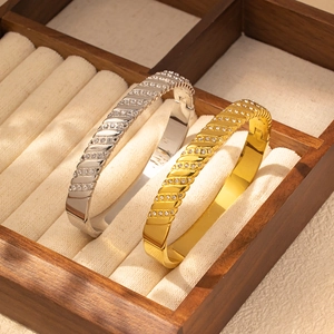 Détail de joncs de luxe en or et argent avec cristaux dans un écrin à bijoux haut de gamme