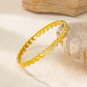 Vista ravvicinata di un bracciale a catena a cuore dorato con zirconi su pietra naturale