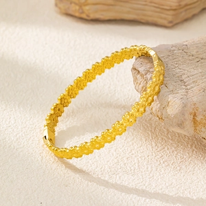 Vista dettagliata del bracciale a quadrifoglio dorato con meccanismo a scatto sicuro