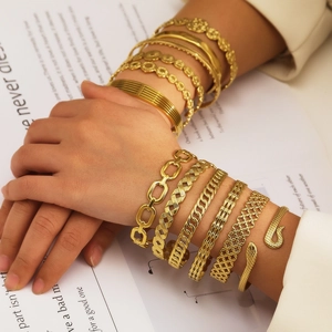 Pile de bracelets et joncs élégants en acier inoxydable plaqué or 18k sur un mannequin