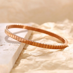 Elegantes Armband aus Roségold-Edelstahl mit geometrischer Textur auf Marmoroberfläche