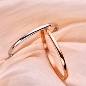 Minimalistische open armband in zilver en roségoud op een elegante satijnen stof