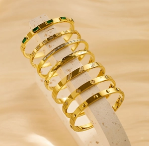 Detailed set of seven gold-plated titanium steel bangles with zircon inlays and textures