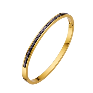 Detailed close-up of gold-plated stainless steel bangle with black zircon channel setting