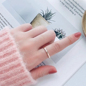 Detailed view of faceted rose gold titanium steel ring with a single centered diamond