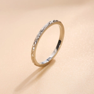 Detailed macro view of the silver diamond-patterned textured stainless steel ring surface