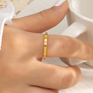 Close-up of minimalist 18k gold plated stainless steel ring with a single zircon on hand