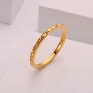 Close-up of geometric diamond-cut facets on 18k gold-plated minimalist steel ring