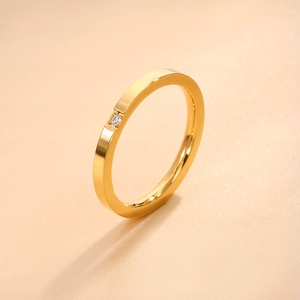 Detailed shot of a minimalist gold stainless steel ring with a single zircon stone inlay