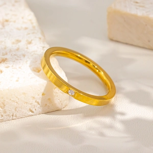 Close-up of a 18k gold-plated stainless steel ring with a single centered diamond