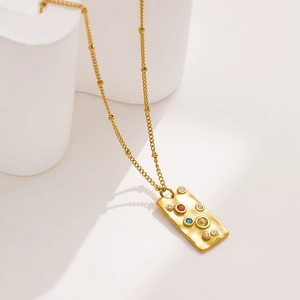 Macro detail of 18k gold plated pendant featuring hammered texture and colorful zircons