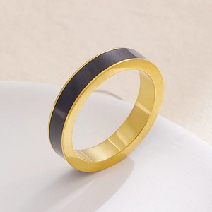 Dettaglio di un anello minimalista in acciaio dorato con elegante inserto in smalto nero