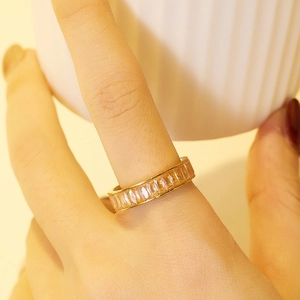 Vue macro d'une bague éternité dorée avec des pierres roses taille baguette serties