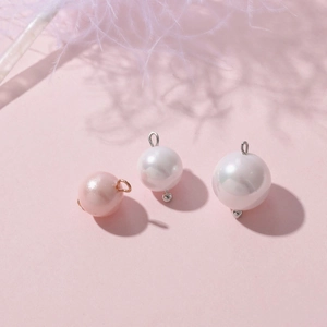 Detailed macro view of faux pearl pendants in pink and white with metal loops