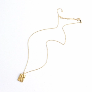 Detailed macro view of the hammered texture on 18K gold-plated titanium steel necklace
