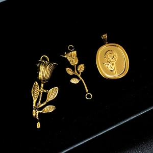Macro shot of 18K gold plated rose flower and sunflower pendant jewelry charms