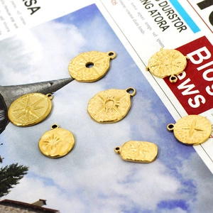 Detail of 18K gold starburst charms with hammered texture for DIY jewelry making