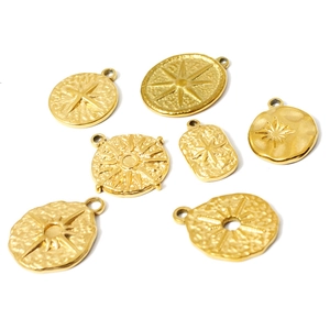 Set of seven gold 18K plated starburst and floral pendants with hammered metal texture