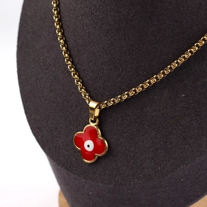 Gold chain necklace featuring a red clover pendant with a protective evil eye design motif