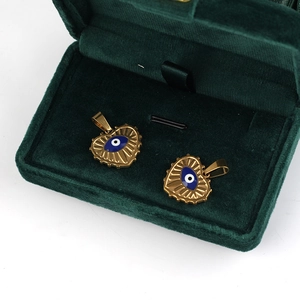 Golden heart-shaped Evil Eye pendant in a luxury green velvet jewelry box gift display