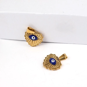 Golden heart-shaped evil eye pendant with radial texture and blue enamel inlay in macro view