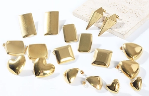 Vue détaillée à plat de boucles d'oreilles géométriques en acier doré sur pierre