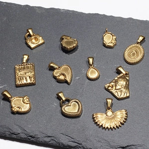 Vintage style 18k gold plated stainless steel heart and eye charms on stone background