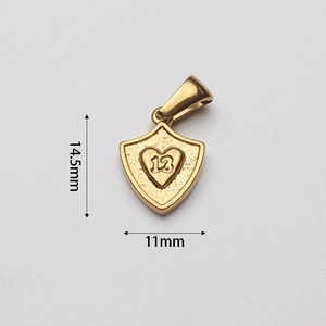 Detailed macro view of a gold shield pendant featuring an engraved heart with the number 13