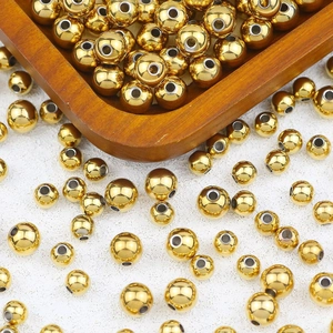 Close-up of polished golden stainless steel round beads with center holes for DIY jewelry