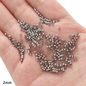 Macro shot of 2mm silver stainless steel beads for DIY jewelry making held in palm