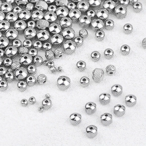 Dettaglio macro di perline distanziatrici in acciaio argento con finiture rigate e lucide