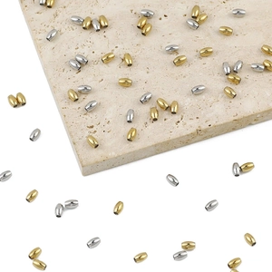 Detailed macro of oval stainless steel spacer beads in gold and silver finish