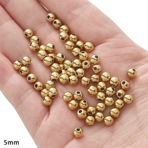 5mm gold stainless steel spacer beads for jewelry making shown in hand for scale