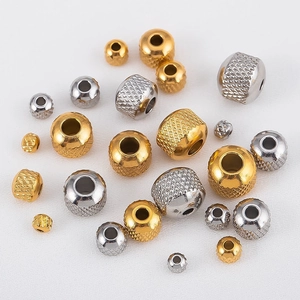 Macro shot of stainless steel beads with diamond grid texture in gold and silver finish