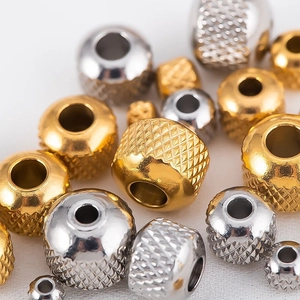 Macro view of gold and silver stainless steel spacer beads with knurled mesh texture