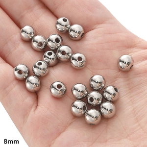 Detailed macro shot of 8mm silver stainless steel spacer beads held in palm