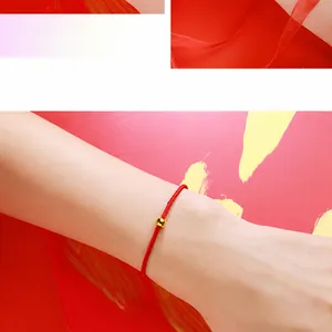 Close-up of red woven cord bracelet with a single gold-plated bead for DIY jewelry
