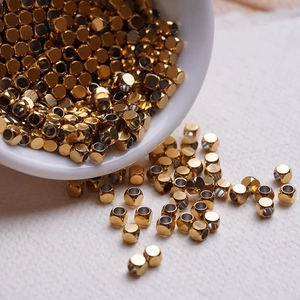 Vue macro de perles en acier inoxydable doré dans un bol pour bijoux DIY
