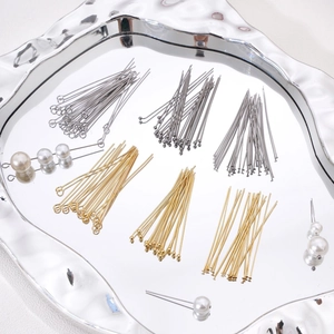 Detailed macro view of gold and silver jewelry making head pins and eye pins on a tray