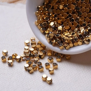 Gros plan de perles cylindriques en acier inoxydable doré pour création de bijoux